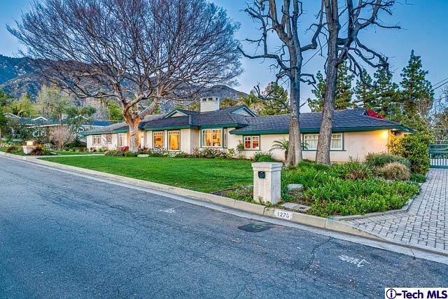 a view of a house with a big yard and large trees