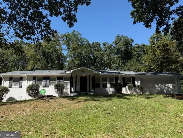a view of a house with a yard and sitting area