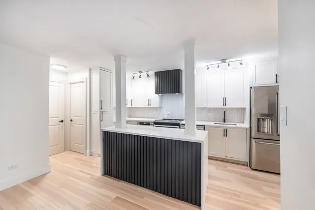 a kitchen with a refrigerator and a stove top oven