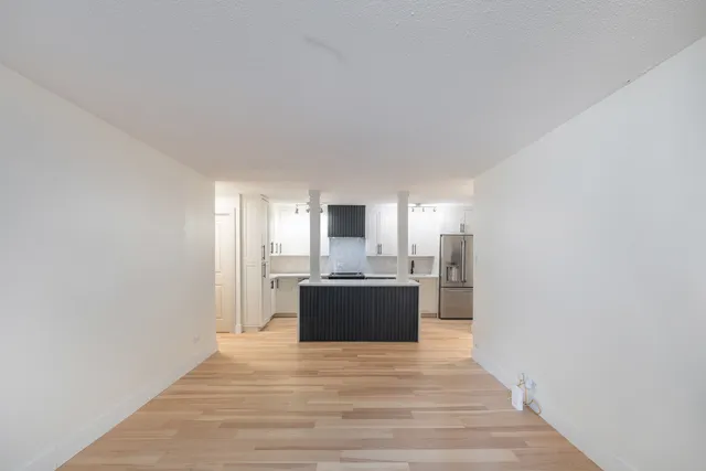 a view of a kitchen with a sink and a refrigerator