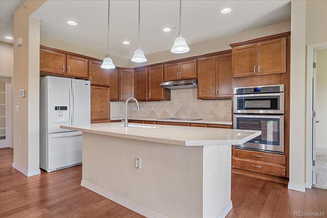 a kitchen with stainless steel appliances granite countertop a sink a refrigerator and a oven
