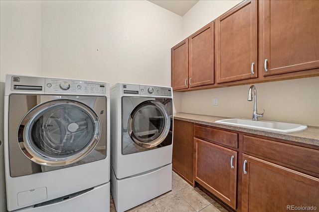an empty room with windows and chandelier fan