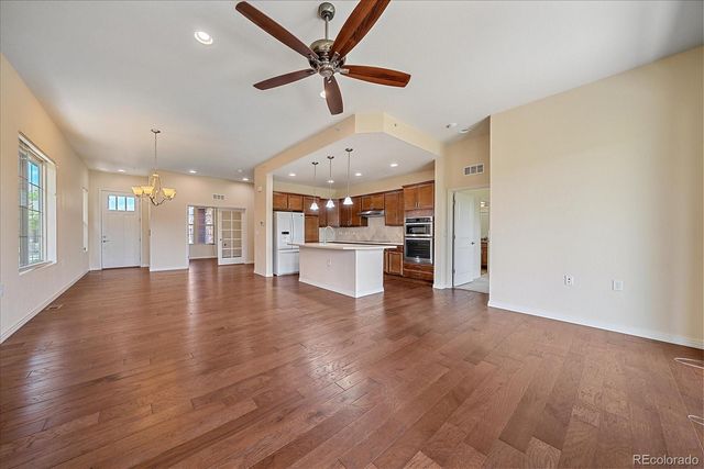 a large kitchen with stainless steel appliances kitchen island a large counter top and a floors