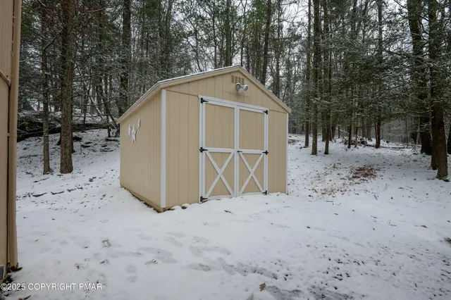 a wooden house with large trees and outdoor space