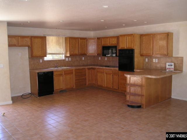 14020 North Red Rock Road Reno, NV 89508 - Photo 3 of 9 a large kitchen with stainless steel appliances granite countertop a stove and a sink
