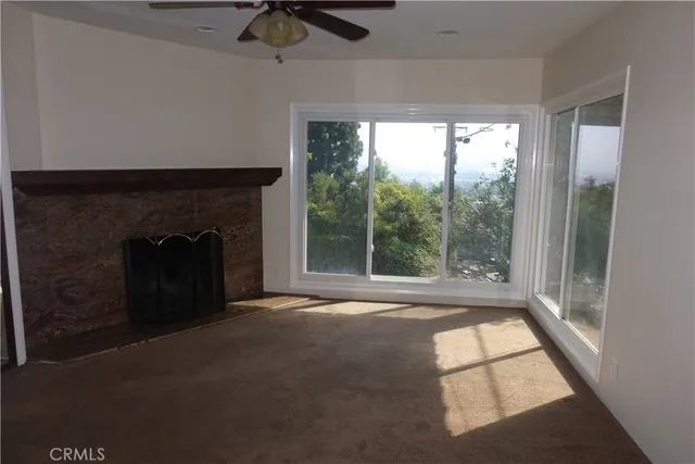 a view of an empty room with windows and a fireplace
