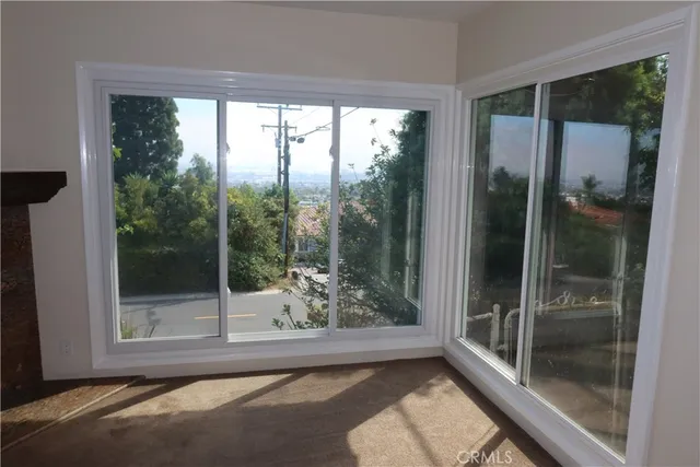 a view of a big room with wooden floor and windows
