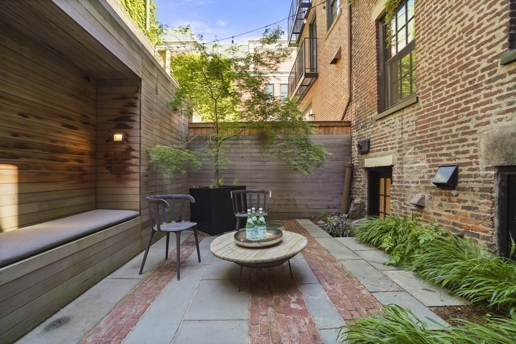 a view of a patio with chairs and plants