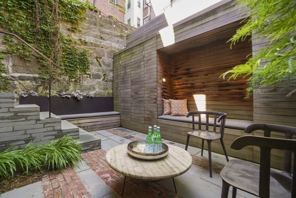 6 Strong Place Boston, MA 02114 - Photo 14 of 38 a backyard of a house with fire pit and outdoor seating