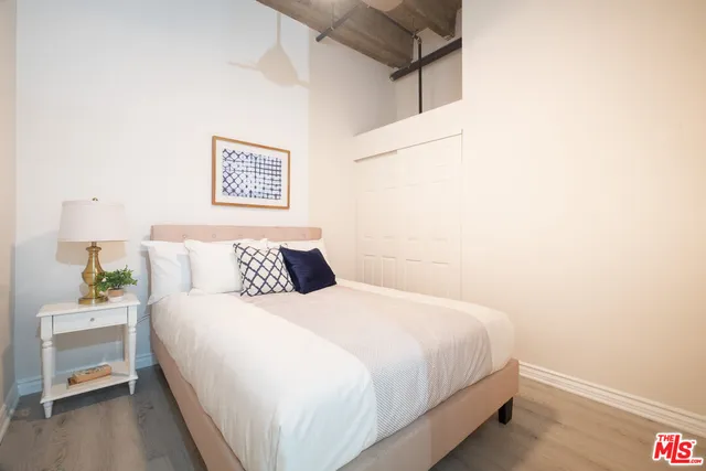 a bedroom with a bed and a lamp on a dresser