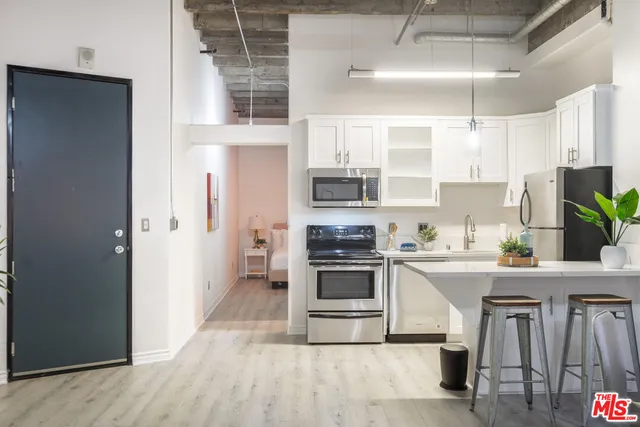 a kitchen with granite countertop a stove a sink and a refrigerator