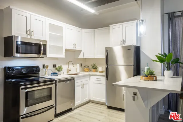 a kitchen with a sink a microwave a refrigerator and cabinets