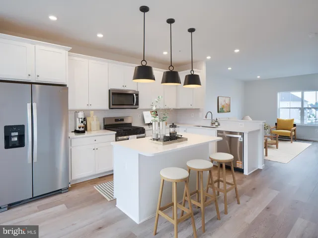 a kitchen with stainless steel appliances a stove a sink a microwave a refrigerator and cabinets