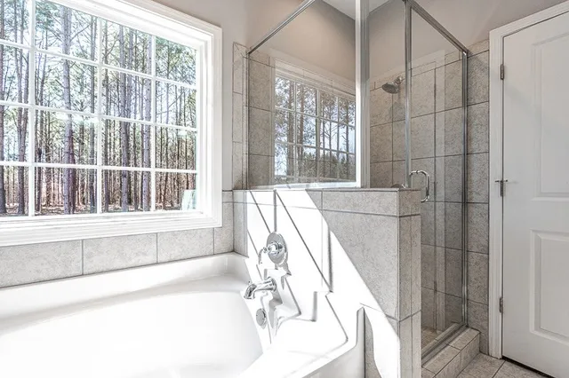 a bathroom with a bathtub and next to a window