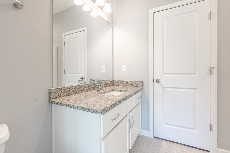 32 Maple Lakes Drive Cataula, GA 31804 - Photo 18 of 27 a bathroom with a granite countertop sink and a mirror