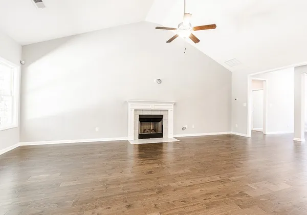 a view of an empty room with a fireplace and a window
