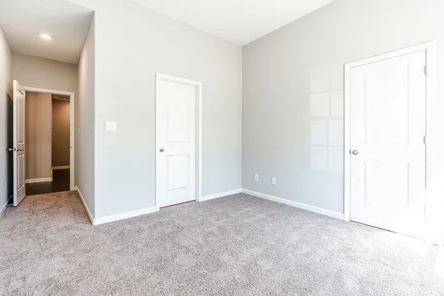 an empty room with closet and a bathroom