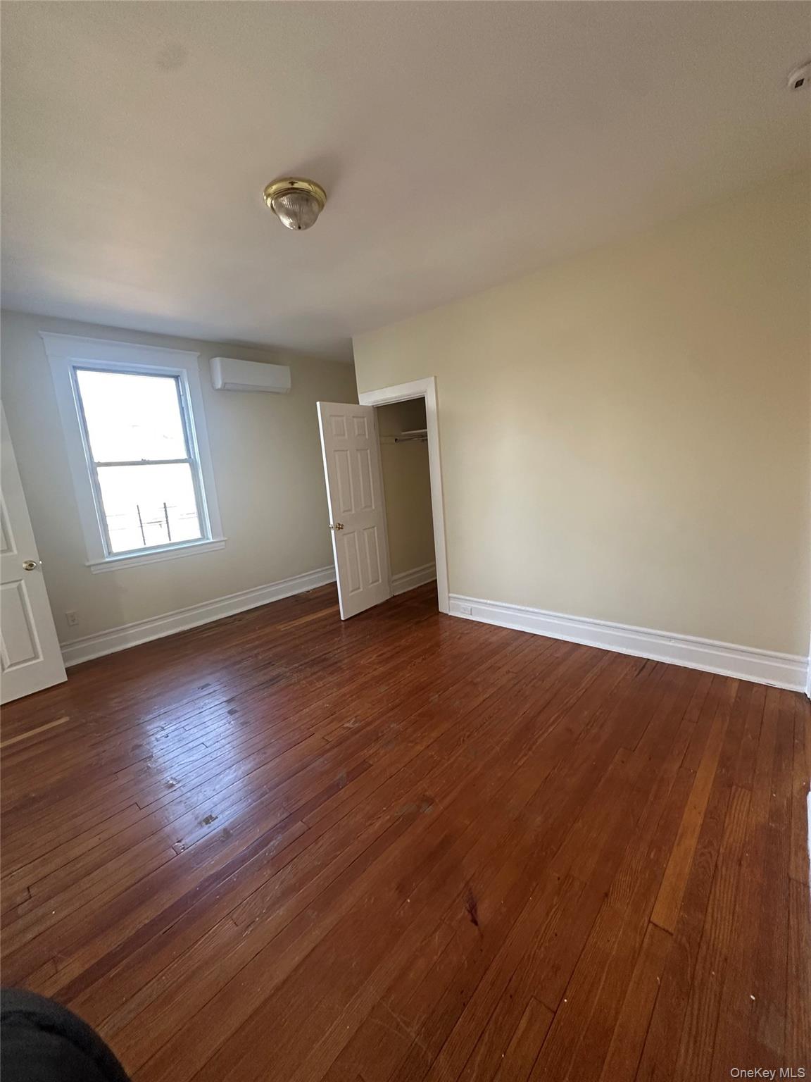 22 Clove Road New Rochelle, NY 10801 - Photo 2 of 11 an empty room with wooden floor and windows