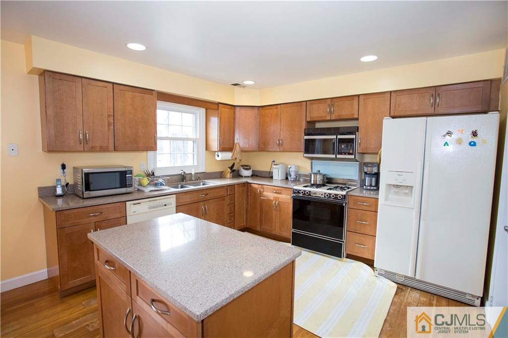 3806 Springbrook Drive Edison, NJ 08820 - Photo 6 of 22 a kitchen with granite countertop a refrigerator a sink dishwasher a stove top oven a refrigerator with island and cabinets