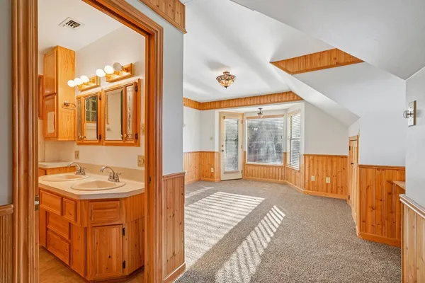 a bathroom with a tub sink and mirror