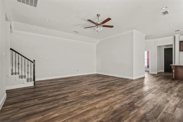 a view of a livingroom with wooden floor and a ceiling fan