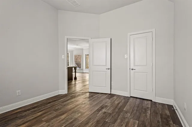 a view of a hallway with wooden floor and closet