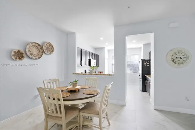 a view of a dining room and kitchen with a table and chairs