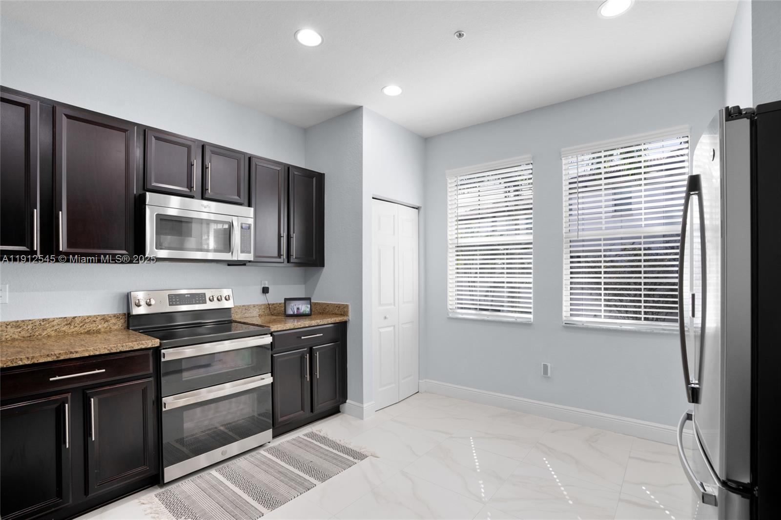 2565 Southwest 119th Terrace Miramar, FL 33025 - Photo 13 of 37 a kitchen with stainless steel appliances granite countertop a stove a sink and a microwave