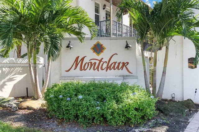 a view of a sign under a tree next to a building