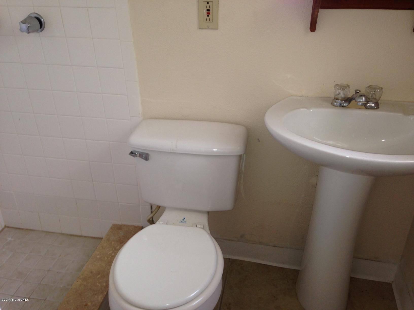 2767 North Breeze Road Melbourne, FL 32935 - Photo 14 of 17 a white toilet sitting next to a white sink