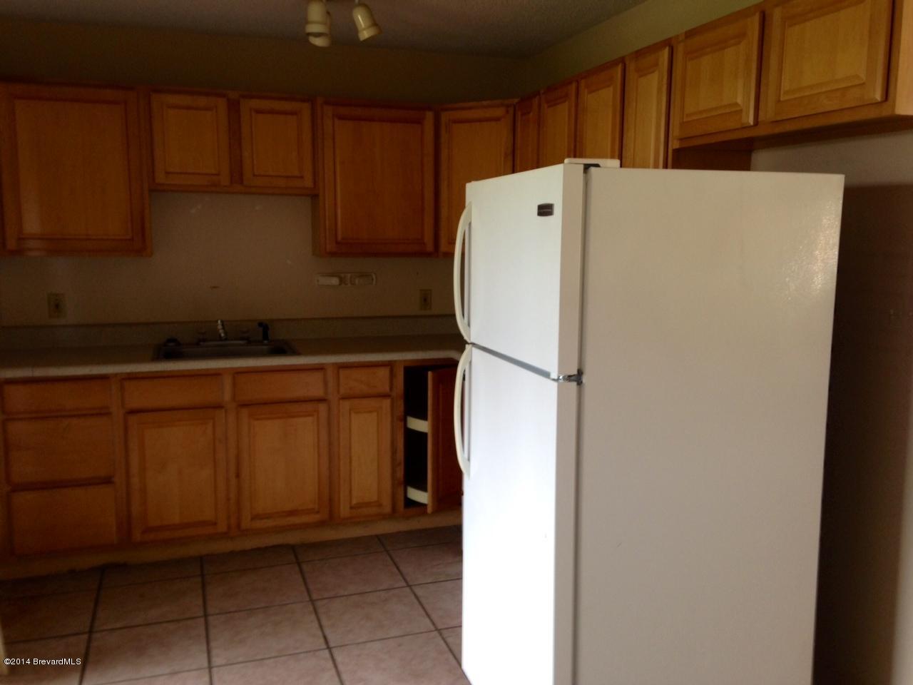 2767 North Breeze Road Melbourne, FL 32935 - Photo 5 of 17 a white refrigerator freezer sitting in a kitchen