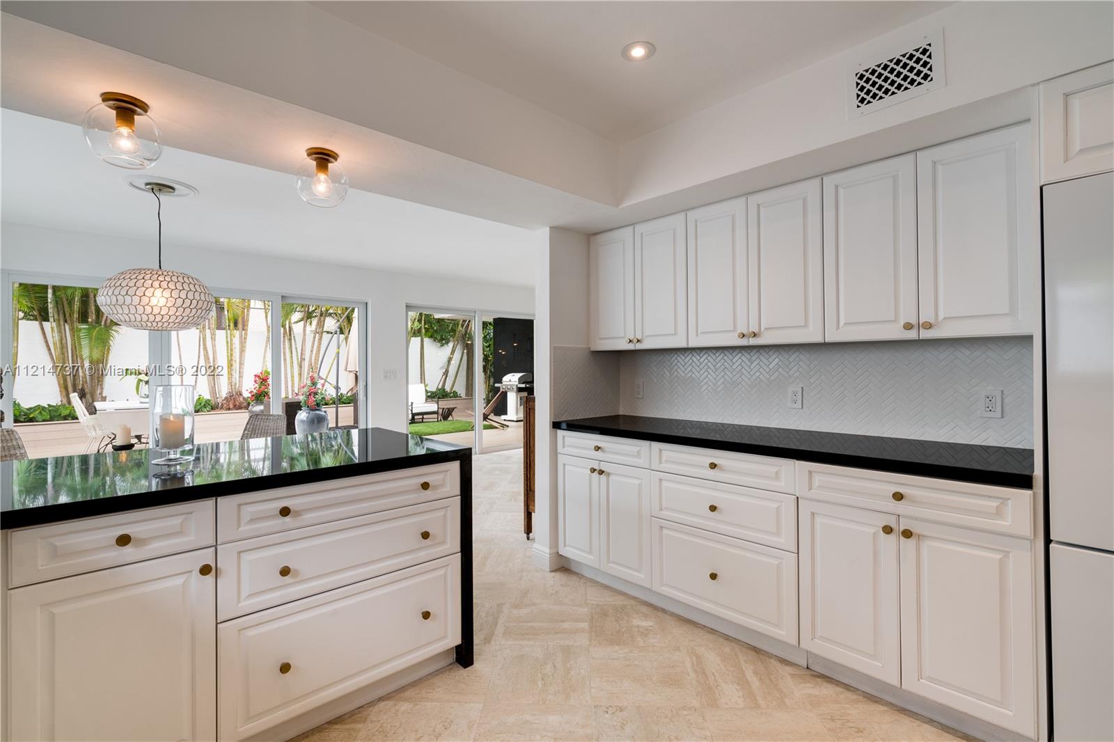 3731 Battersea Road Miami, FL 33133 - Photo 13 of 44 a kitchen with granite countertop white cabinets and white stainless steel appliances