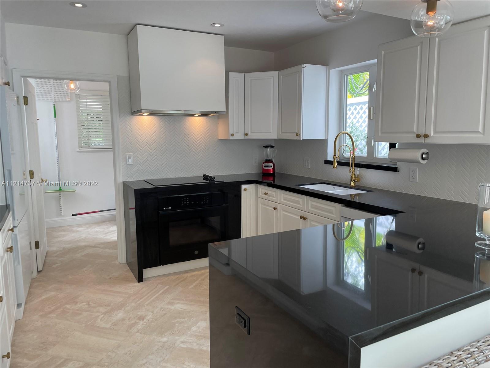 3731 Battersea Road Miami, FL 33133 - Photo 14 of 44 a kitchen with stainless steel appliances granite countertop a sink and a stove