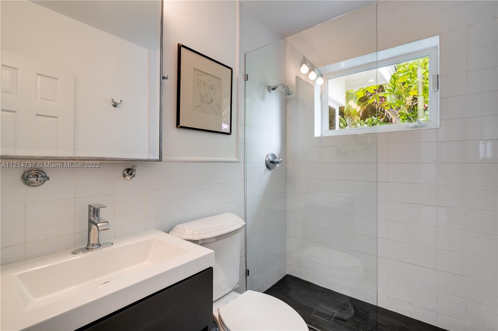 3731 Battersea Road Miami, FL 33133 - Photo 22 of 44 a bathroom with a sink a toilet and shower