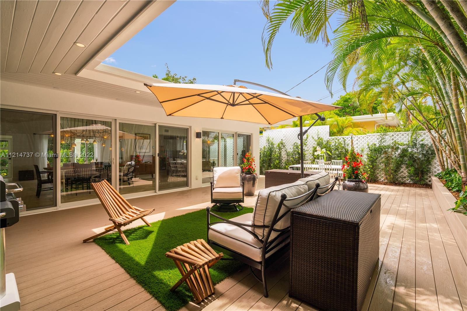 3731 Battersea Road Miami, FL 33133 - Photo 26 of 44 a view of a patio with couches table and chairs under an umbrella with a barbeque