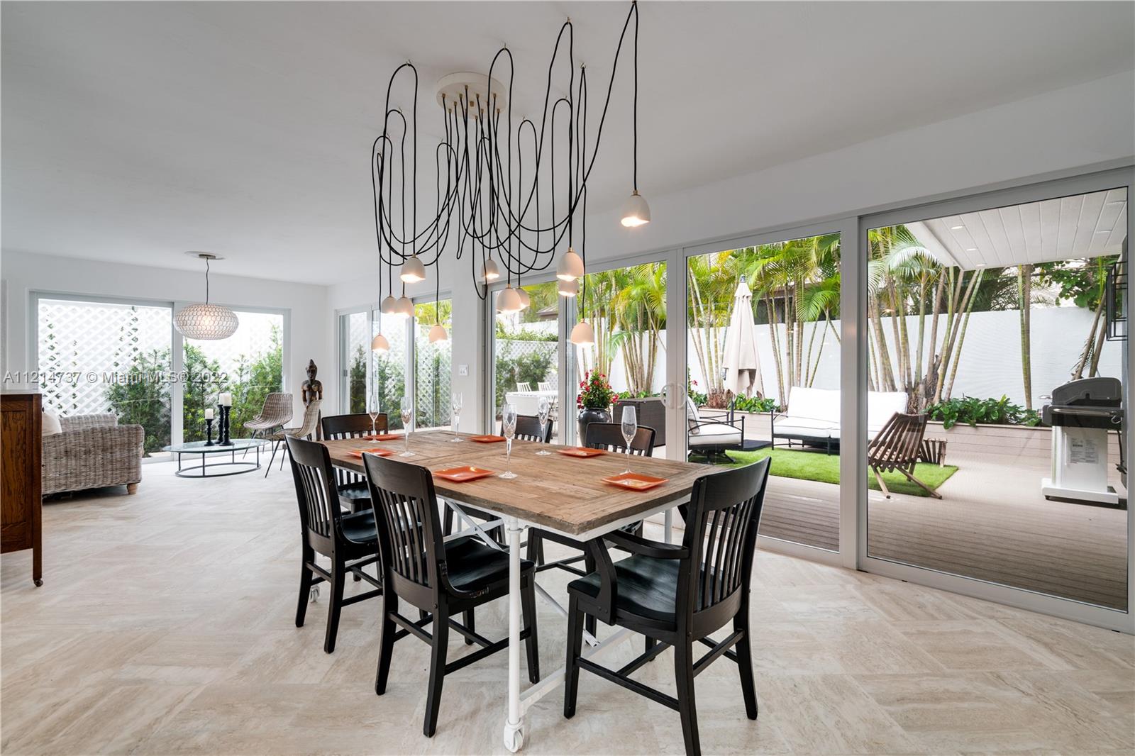3731 Battersea Road Miami, FL 33133 - Photo 40 of 44 a dining room with furniture a chandelier and a rug