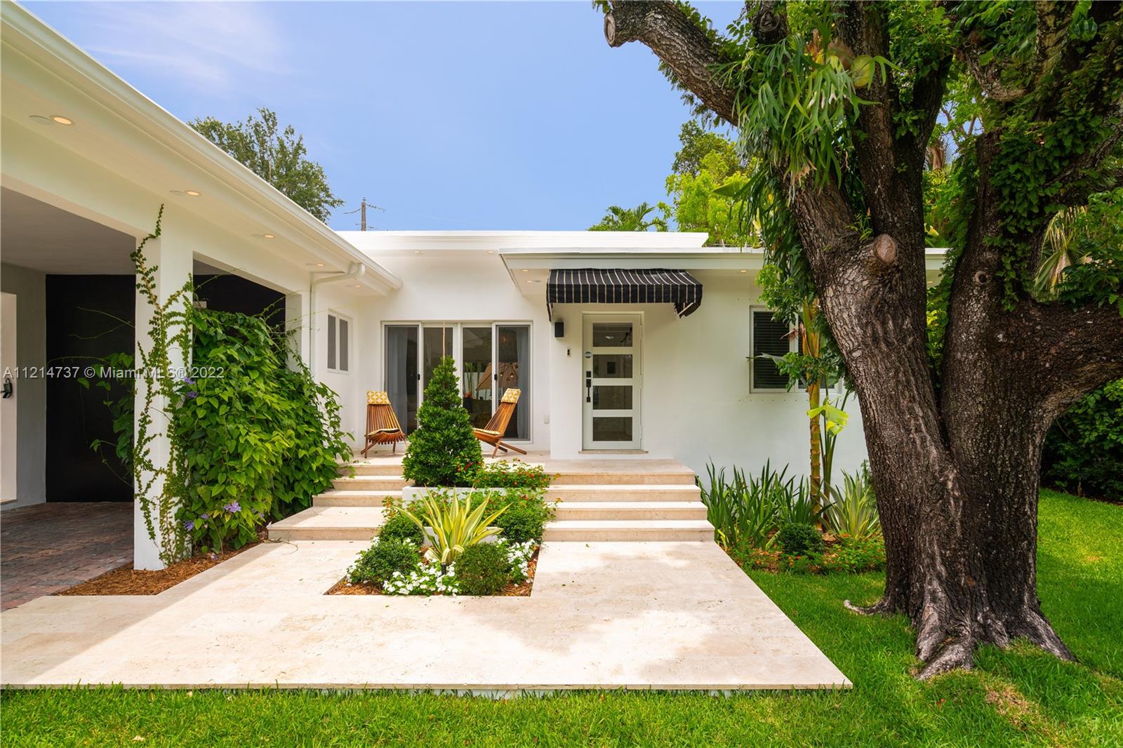 3731 Battersea Road Miami, FL 33133 - Photo 4 of 44 a front view of a house with a yard and potted plants