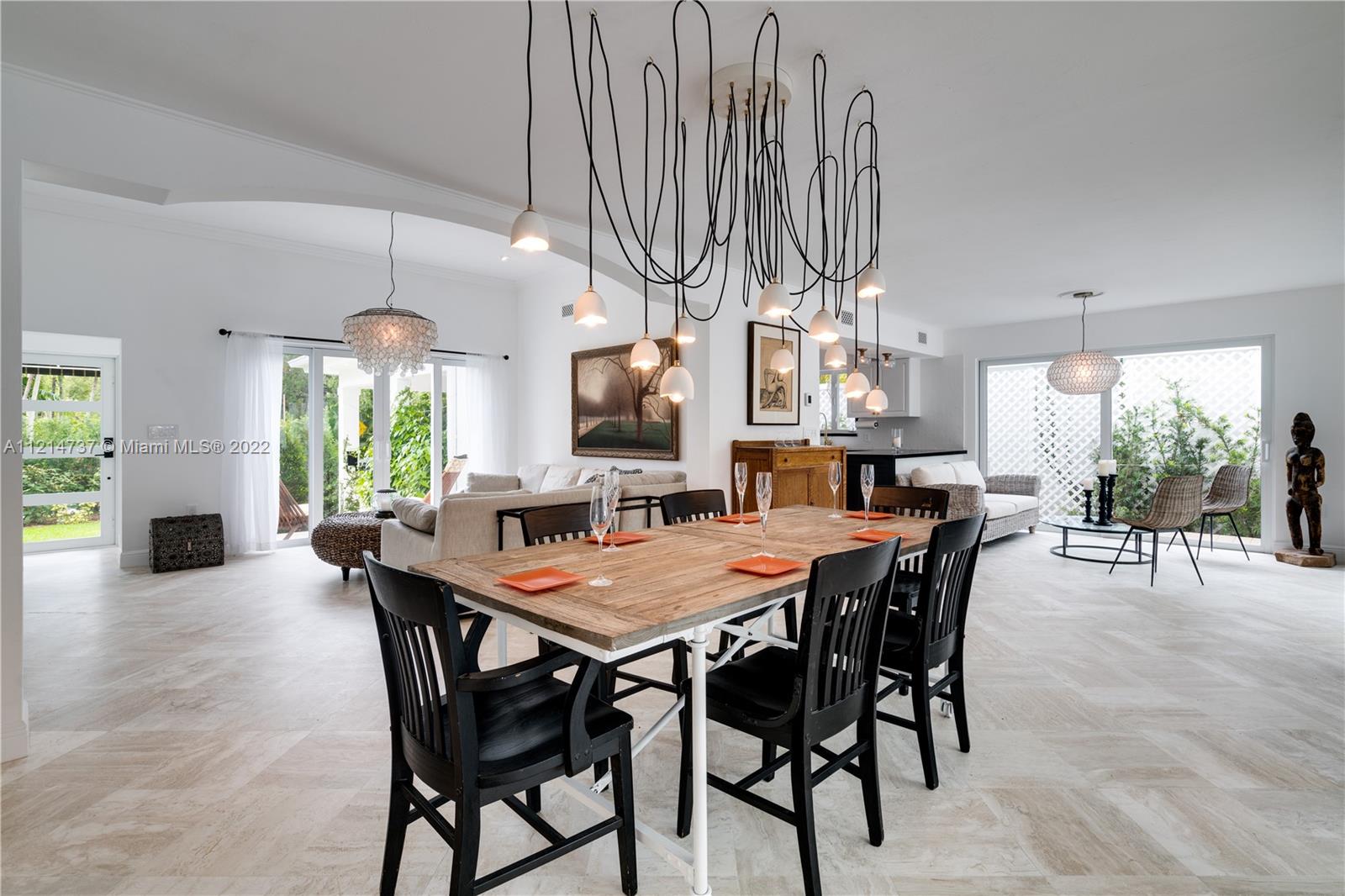 3731 Battersea Road Miami, FL 33133 - Photo 9 of 44 a view of a dining room and livingroom with furniture wooden floor a chandelier