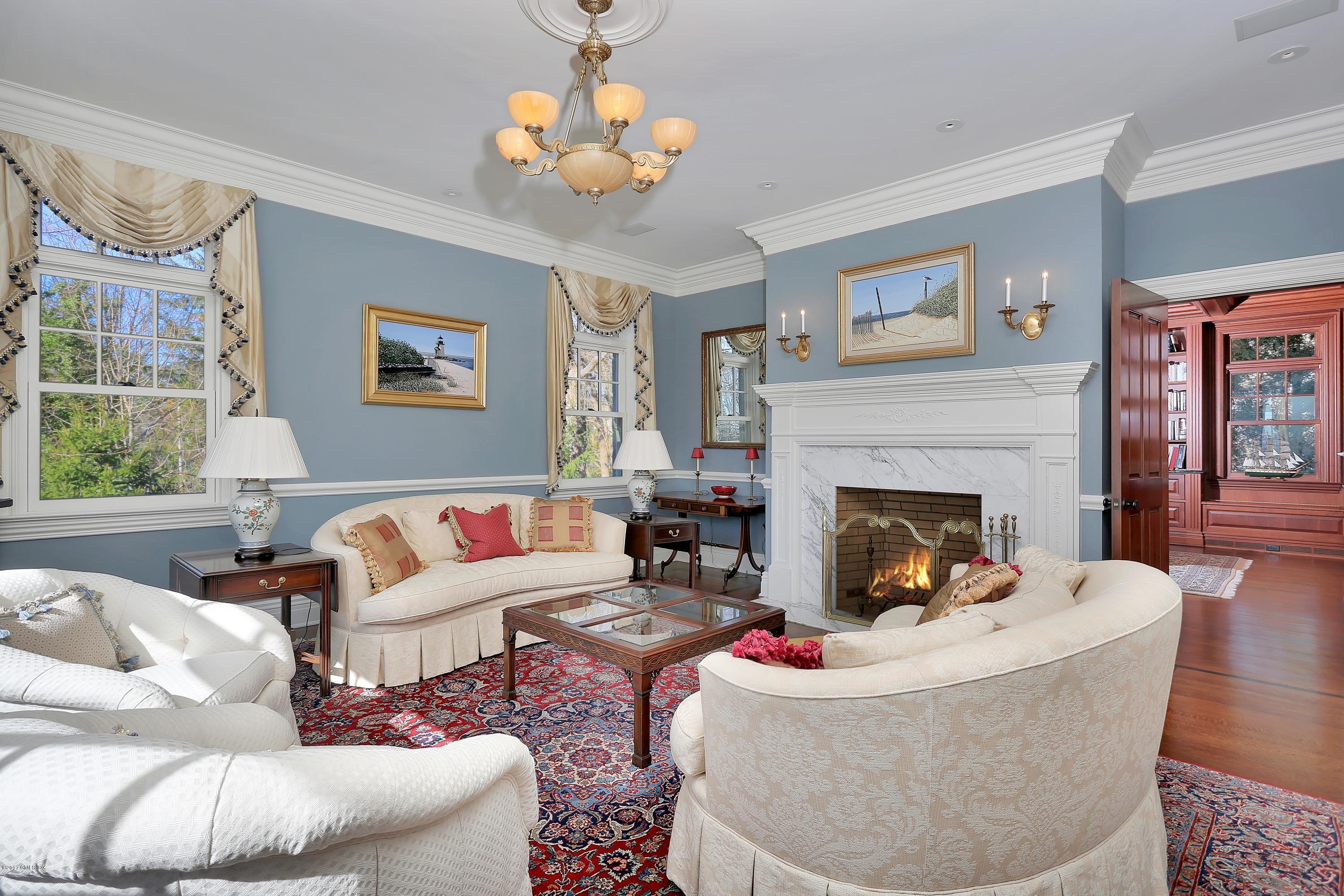 41 Leeward Lane Riverside, CT 06878 - Photo 5 of 27 a living room with furniture a chandelier and a fireplace