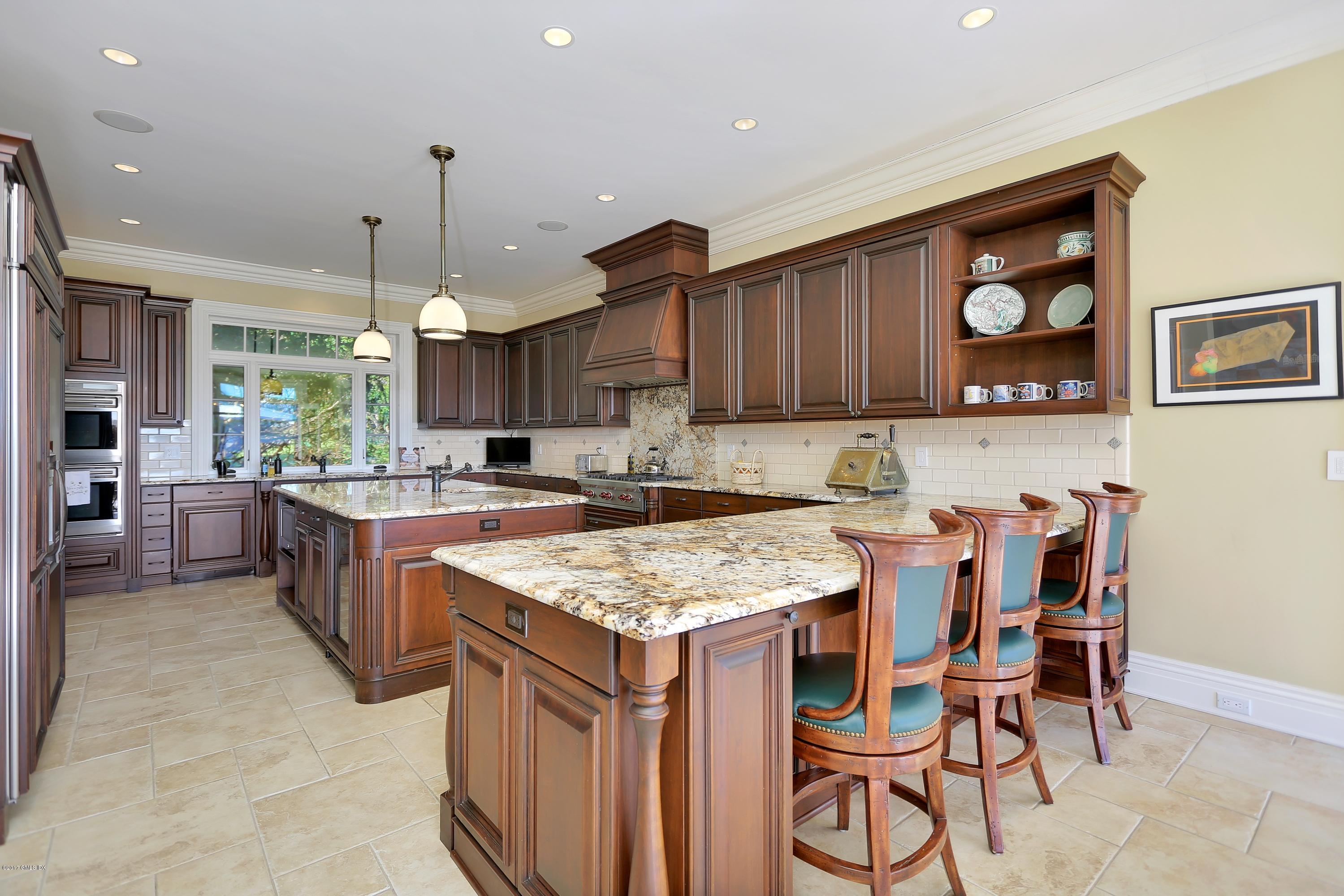 41 Leeward Lane Riverside, CT 06878 - Photo 8 of 27 a kitchen with granite countertop a table chairs stove and cabinets