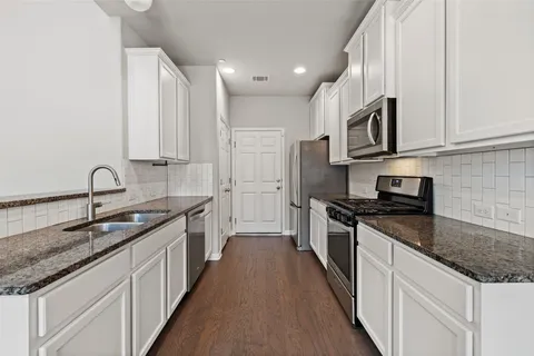 a kitchen with stainless steel appliances granite countertop a sink stove and cabinets