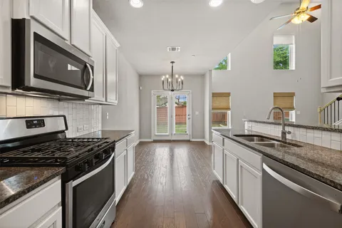 a kitchen with stainless steel appliances granite countertop a stove and a microwave