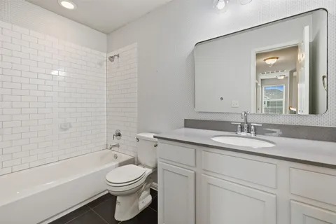 a bathroom with a granite countertop toilet sink and mirror