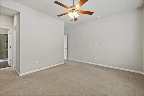 an empty room with closet and a chandelier fan