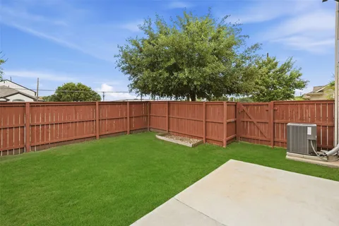 a view of a backyard with wooden fence