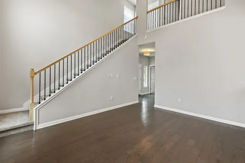 a view of staircase with wooden floor and white walls