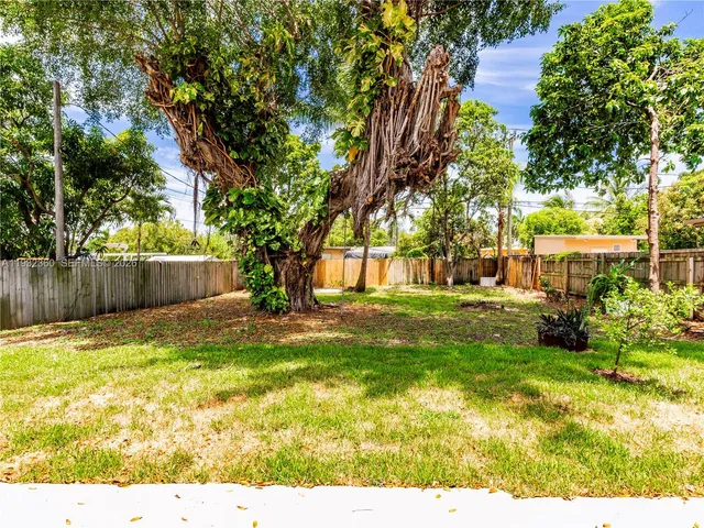 a view of yard with tree in the background