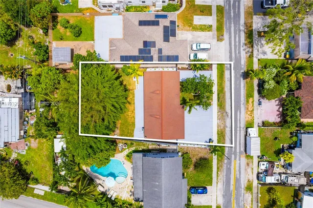 an aerial view of residential houses with outdoor space and swimming pool