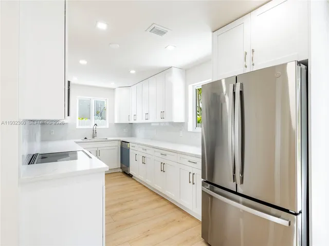 a kitchen with stainless steel appliances a refrigerator sink and cabinets