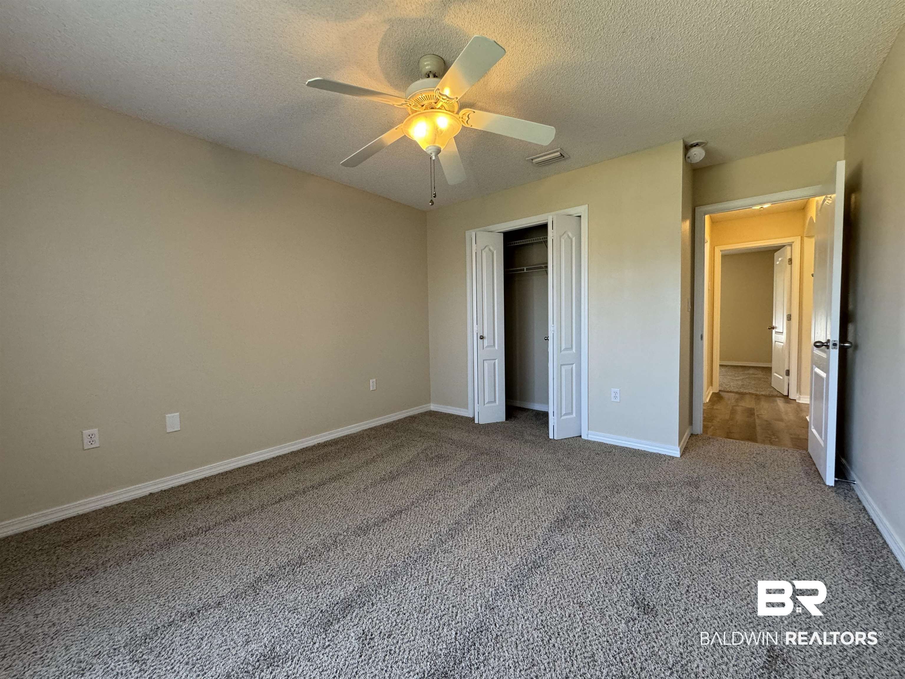32769 Arbor Ridge Circle Lillian, AL 36549 - Photo 22 of 36 Unfurnished bedroom featuring ceiling fan, a textured ceiling, a closet, and carpet